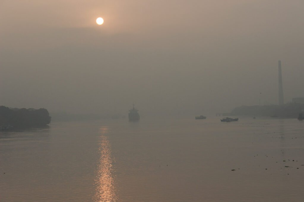 Photographie artistique d'un lever de soleil sur le fleuve indien, la rivière Hoogly. La brume matinale de cette œuvre très picturale et onirique rappelle le tableau impressionniste de Monet Impression Soleil levant. Une photographie d'art aux tonalités rose poudré et gris qui en vente en édition limitée et signée. Douceur, sérénité, et rêves se dégagent de cette œuvre éditée sur papier fine art. Cette photographie artistique prise en Inde séduira les rêveurs, les galeries d'art et les collectionneurs attirés par la photographie picturale. Une photo méditative et spirituelle qui emporte le spectateur vers un ailleurs divin empli de douceur pour décorer un intérieur en ouvrant une fenêtre sur les beautés du Monde.